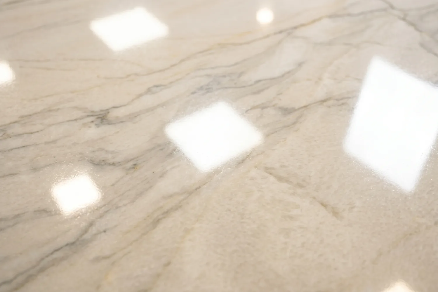 Close-up of a polished quartzite countertop surface showing high-gloss mirror finish with sharp bright reflections and full color saturation