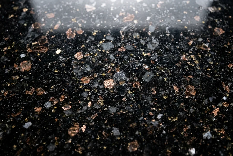 Polished black granite slab with mineral flecks